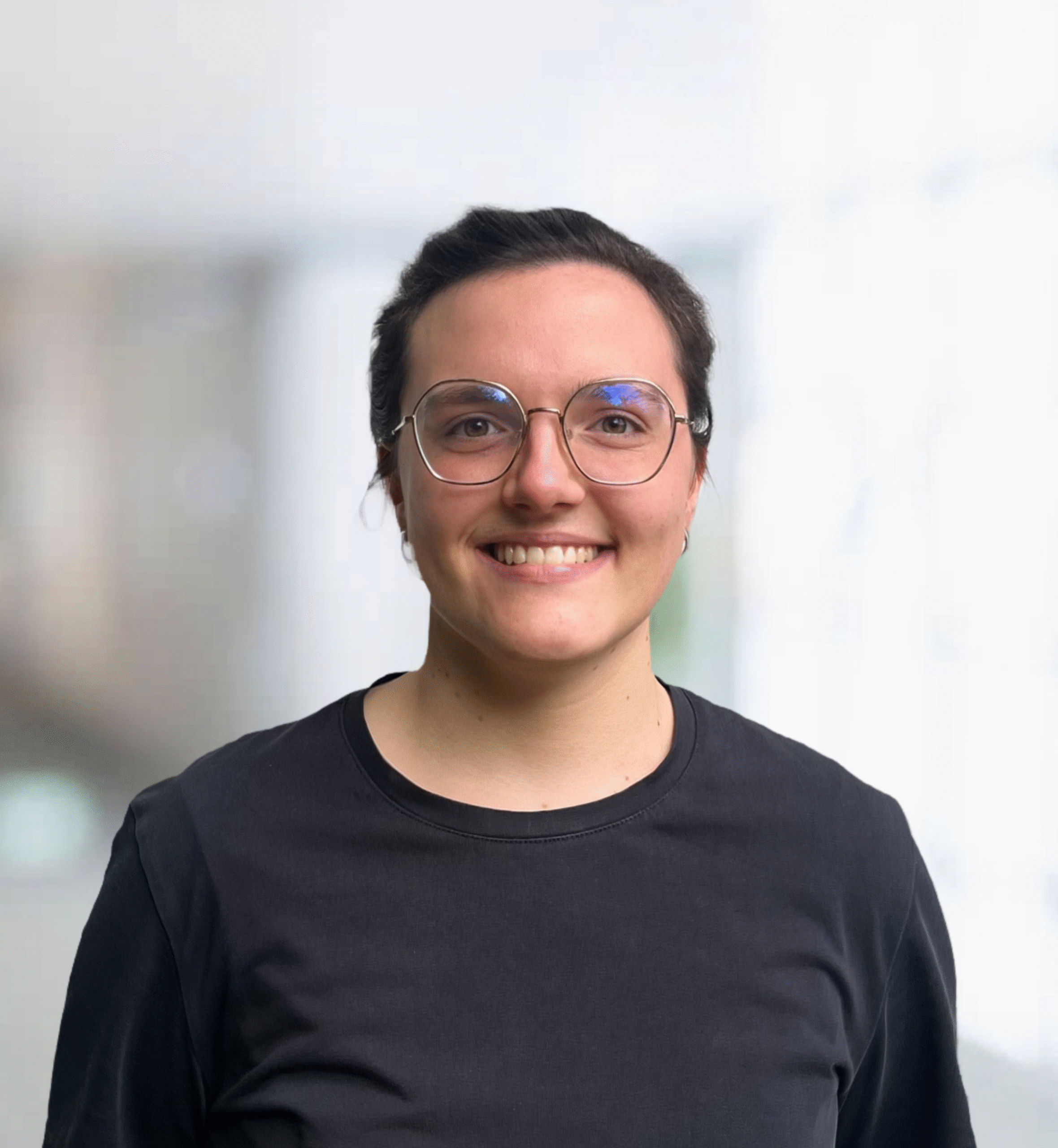 Anita Tomme vor einem neutralen, hellen Hintergrund