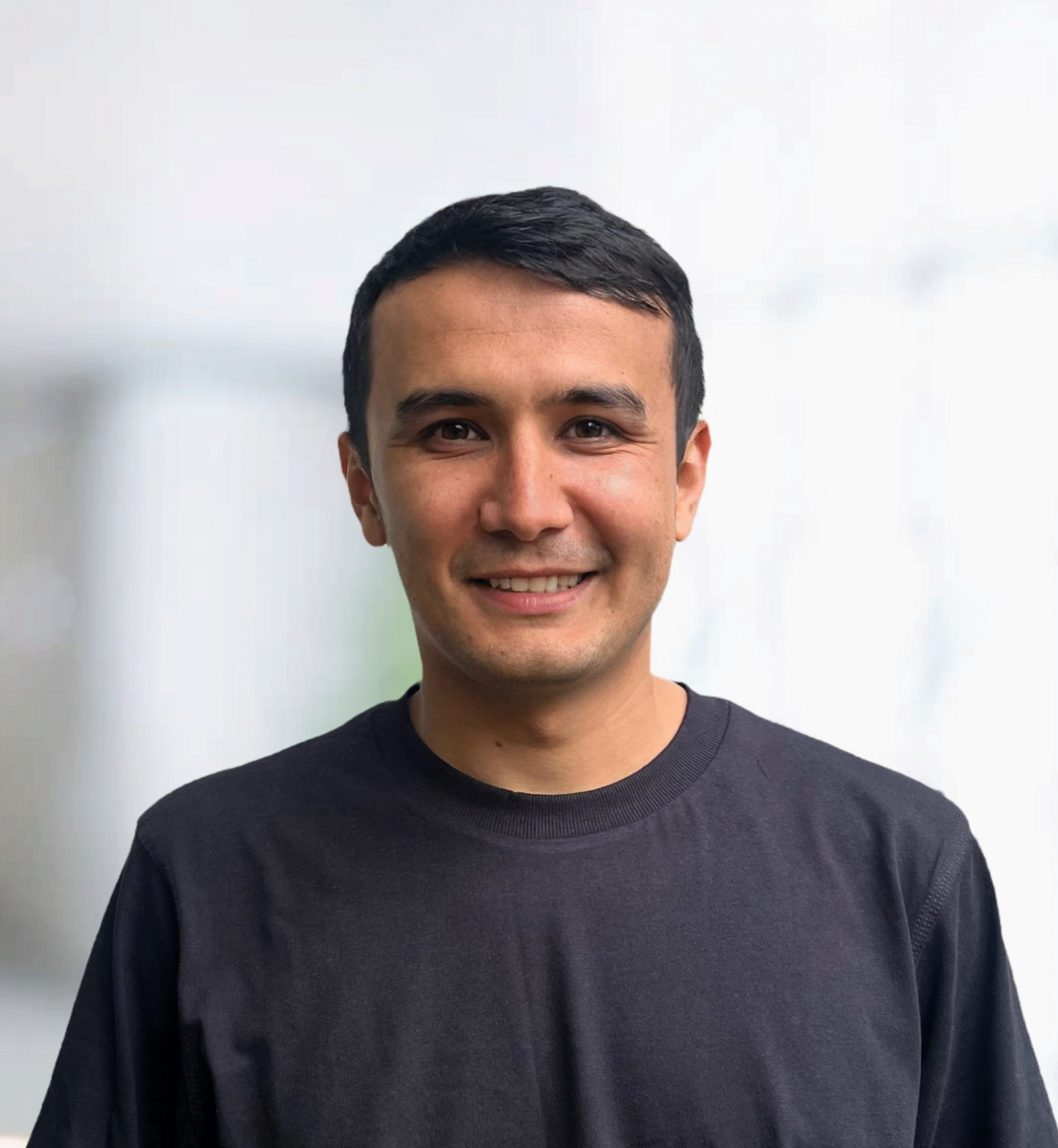 Eldor Eshniyozov vor einem neutralen, hellen Hintergrund am Smart Future Campus